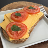 Torrada de pão orgânico com queijo de castanha de caju, tomate e manjericão