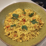 Galinhada com arroz e especiarias (cúrcuma, páprica e cominho), filé de frango desfiado, ervilha, tomate e cenoura.