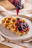 Waffle de pão de queijo vegano com calda de frutas vermelhas ou goiabada